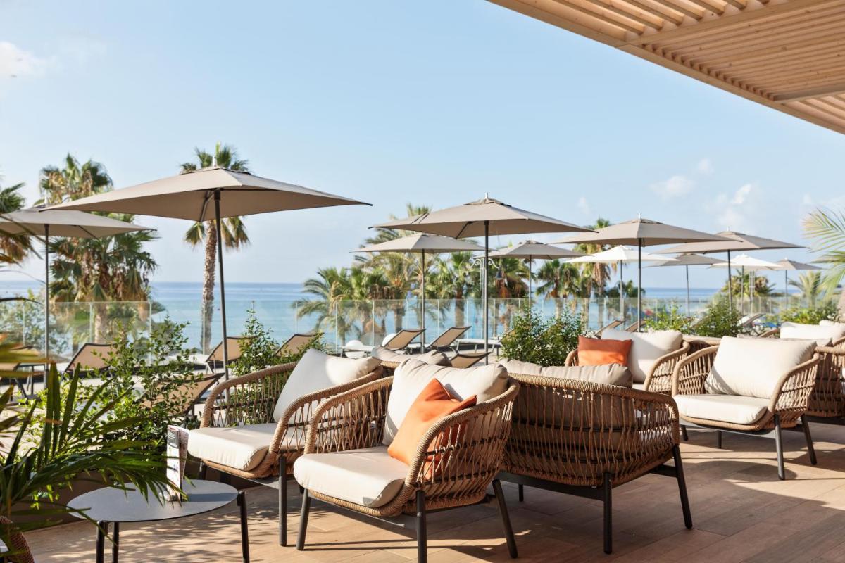Un patio con sillas y sombrillas y el océano. en Hotel Best Triton, en Benalmádena