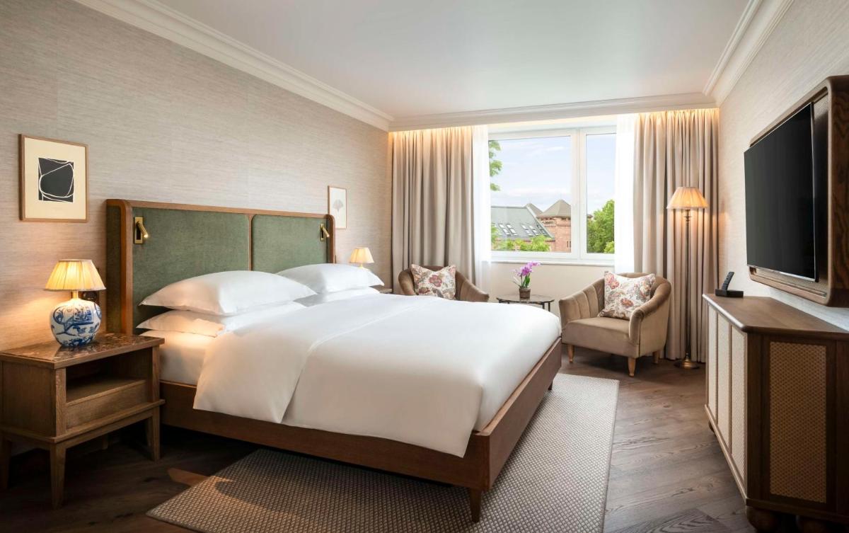 ein Schlafzimmer mit einem großen Bett und einem großen Fenster in der Unterkunft Brunfels Hotel, in the Unbound Collection by Hyatt in Mainz