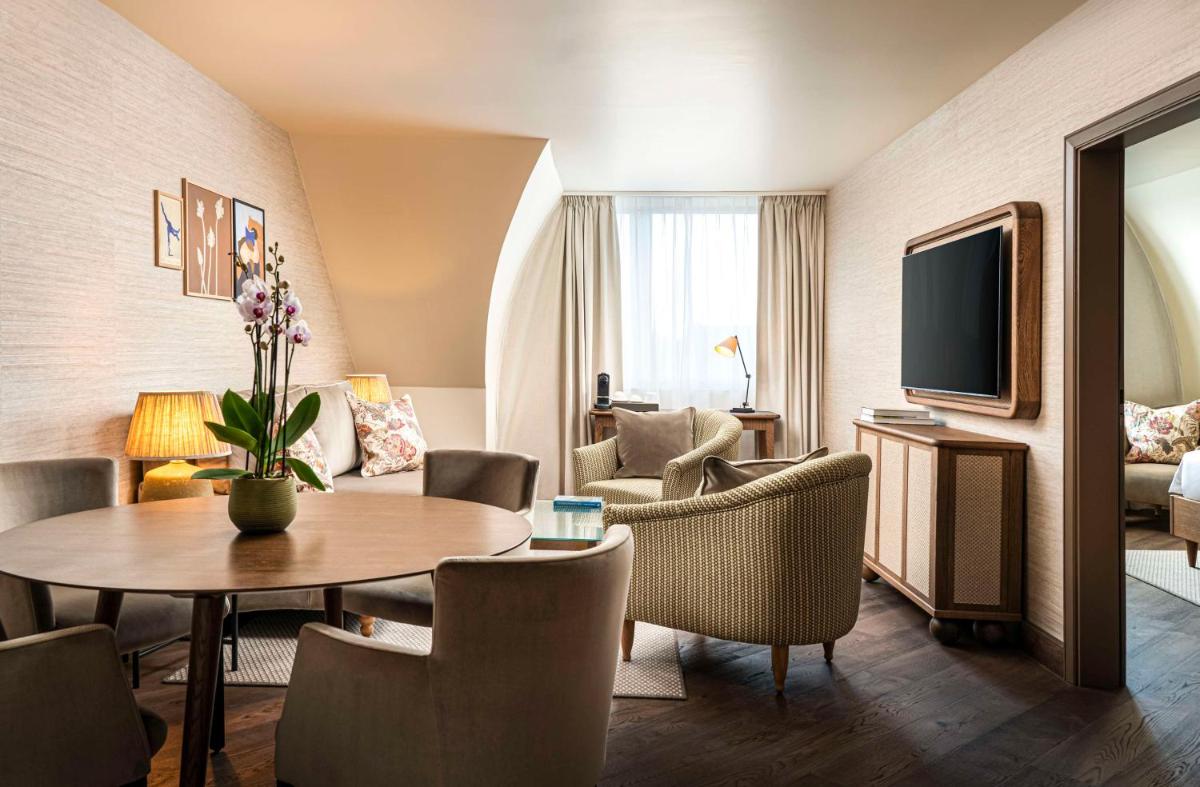 ein Wohnzimmer mit Tisch und Stühlen in der Unterkunft Brunfels Hotel, in the Unbound Collection by Hyatt in Mainz