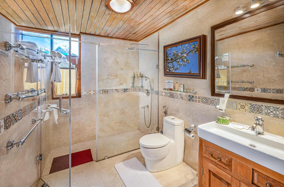 a bathroom with a shower and a toilet and a sink at Storii By ITC Hotels Urvashis Retreat, Manali in Manāli a bathroom with a shower and a toilet and a sink at Storii By ITC Hotels Urvashis Retreat, Manali in Manāli