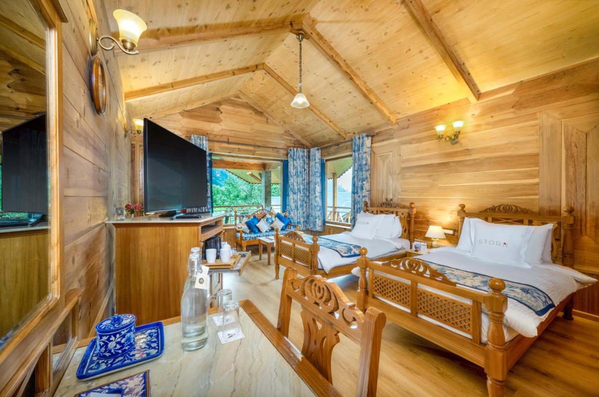 a bedroom with two beds and a flat screen tv at Storii By ITC Hotels Urvashis Retreat, Manali in Manāli a bedroom with two beds and a flat screen tv at Storii By ITC Hotels Urvashis Retreat, Manali in Manāli