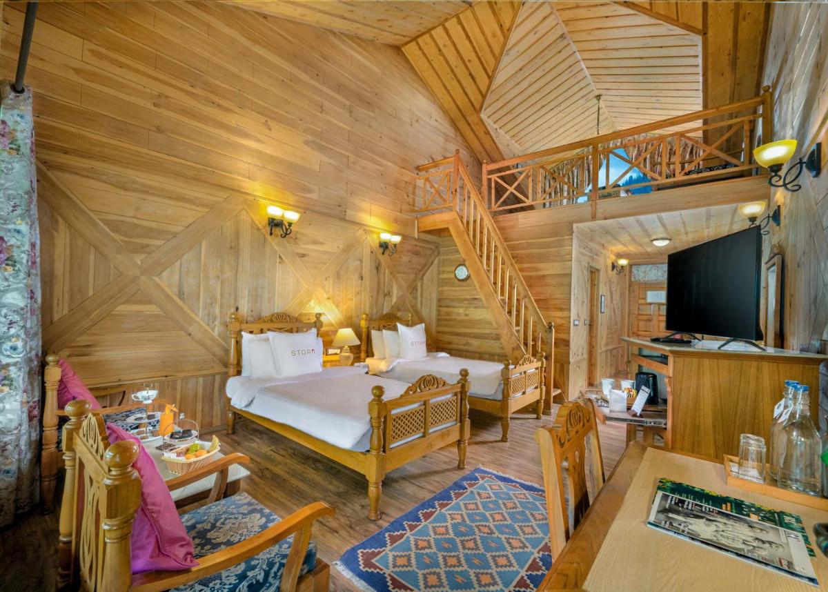 a bedroom with a bed and a staircase in a room at Storii By ITC Hotels Urvashis Retreat, Manali in Manāli a bedroom with a bed and a staircase in a room at Storii By ITC Hotels Urvashis Retreat, Manali in Manāli