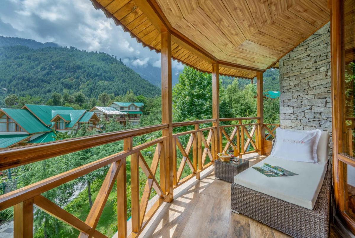 a porch with a chair and a view of a mountain at Storii By ITC Hotels Urvashis Retreat, Manali in Manāli a porch with a chair and a view of a mountain at Storii By ITC Hotels Urvashis Retreat, Manali in Manāli