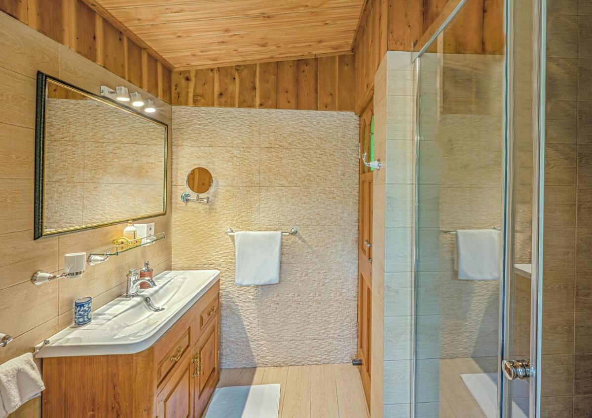 a bathroom with a shower and a sink and a mirror at Storii By ITC Hotels Urvashis Retreat, Manali in Manāli a bathroom with a shower and a sink and a mirror at Storii By ITC Hotels Urvashis Retreat, Manali in Manāli
