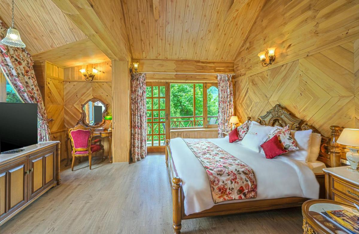 a bedroom with a bed and a tv in a room at Storii By ITC Hotels Urvashis Retreat, Manali in Manāli a bedroom with a bed and a tv in a room at Storii By ITC Hotels Urvashis Retreat, Manali in Manāli