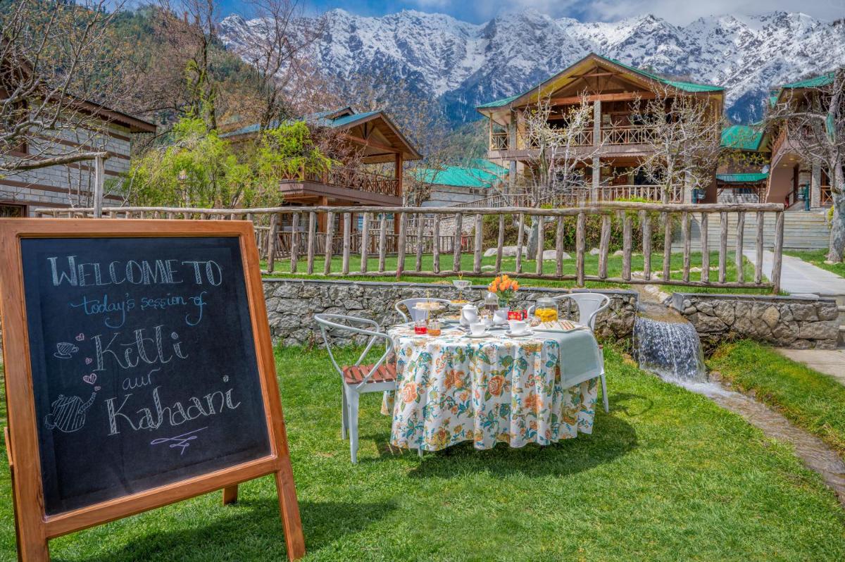 a table with a sign in front of a house at Storii By ITC Hotels Urvashis Retreat, Manali in Manāli a table with a sign in front of a house at Storii By ITC Hotels Urvashis Retreat, Manali in Manāli