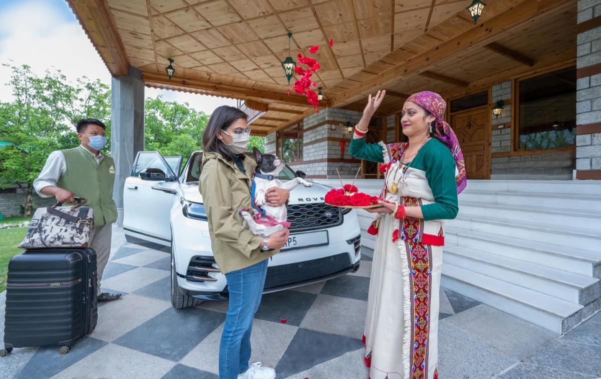 two women wearing face masks holding a baby in front of a car at Storii By ITC Hotels Urvashis Retreat, Manali in Manāli two women wearing face masks holding a baby in front of a car at Storii By ITC Hotels Urvashis Retreat, Manali in Manāli