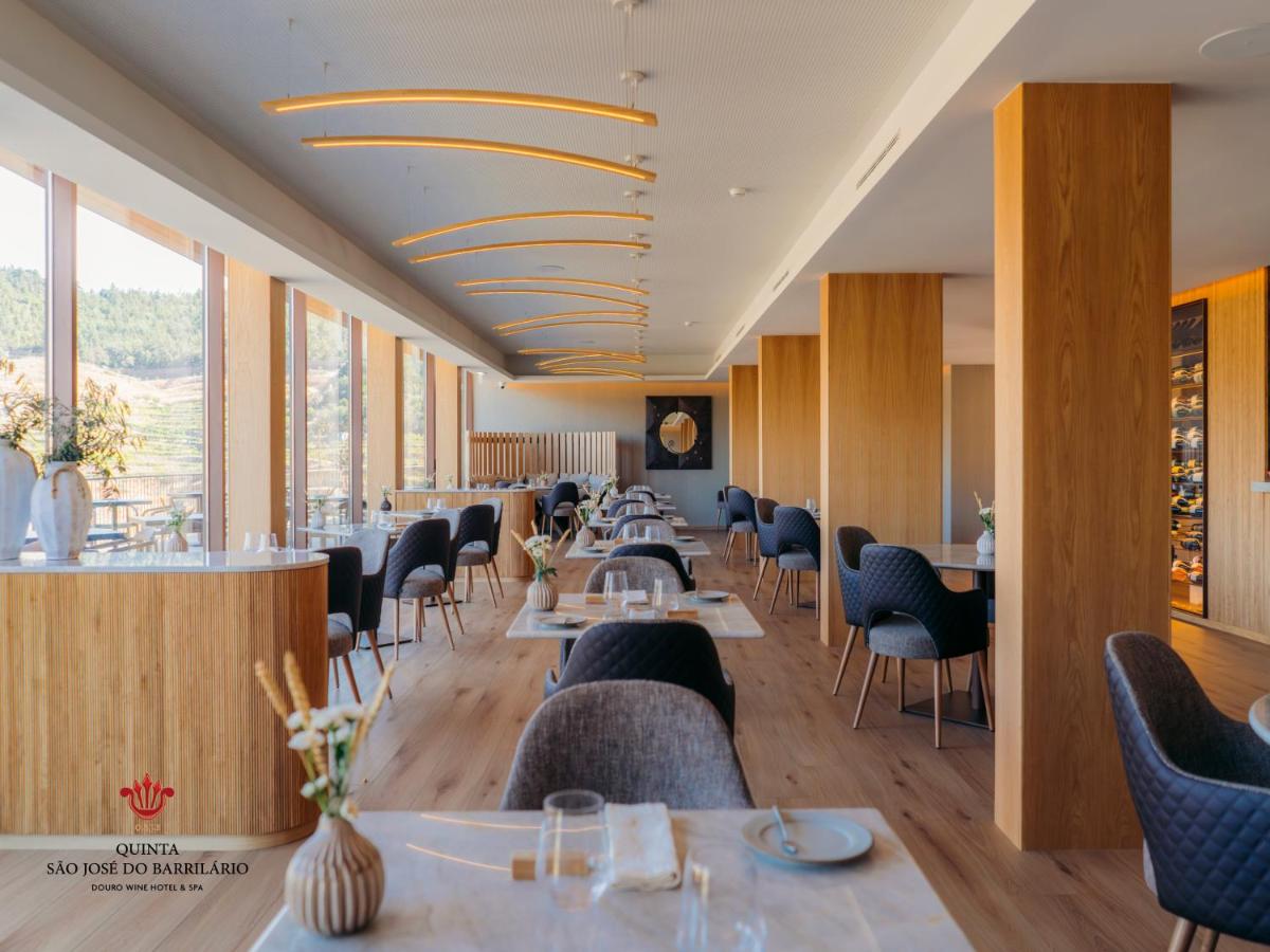 uma sala de jantar com mesas, cadeiras e janelas em Barrilario Douro Wine Hotel e Spa - Quinta São Jose do Barrilario em Armamar