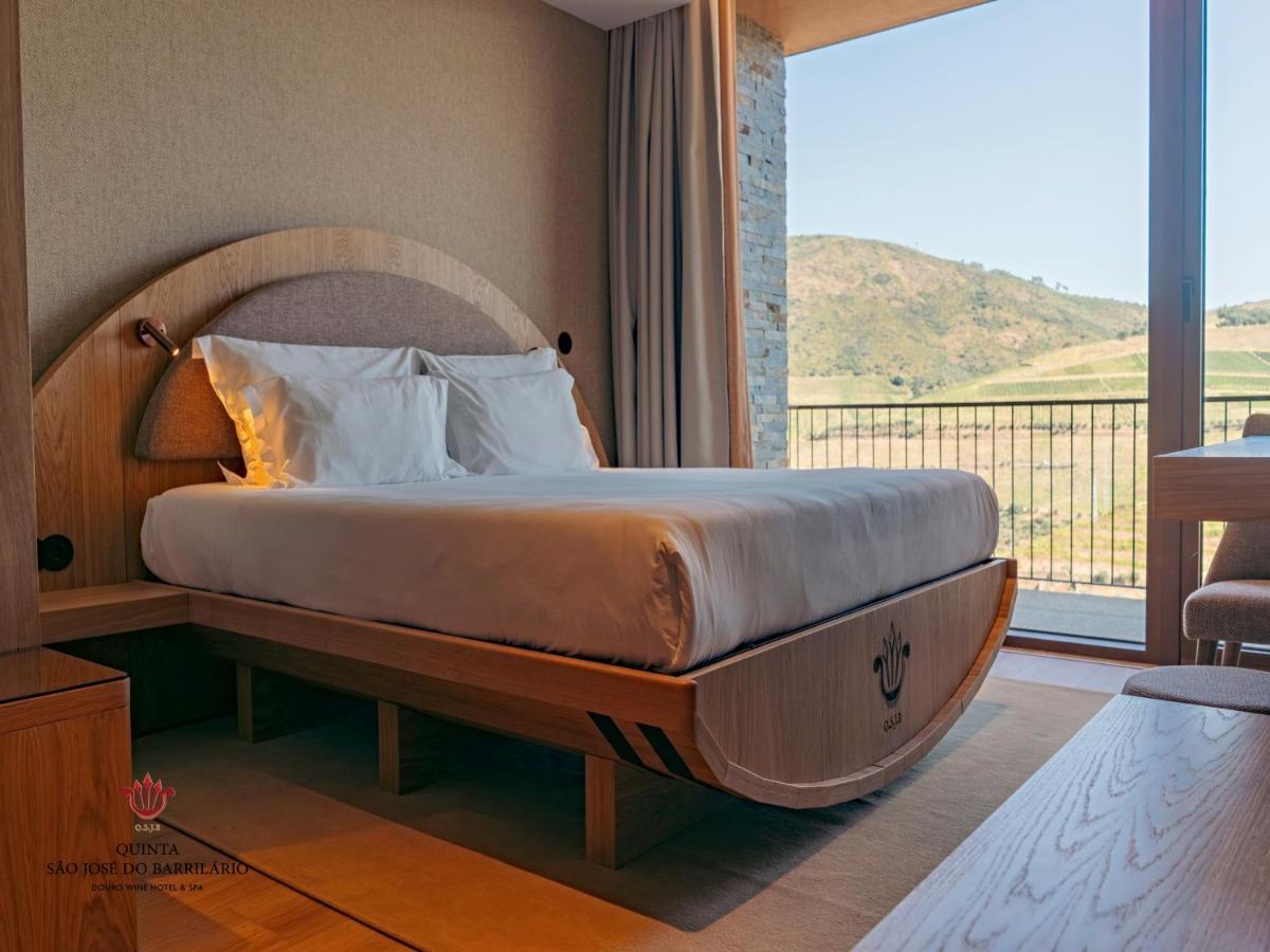um quarto com uma cama grande e uma janela grande em Barrilario Douro Wine Hotel e Spa - Quinta São Jose do Barrilario em Armamar um quarto com uma cama grande e uma janela grande em Barrilario Douro Wine Hotel e Spa - Quinta São Jose do Barrilario em Armamar