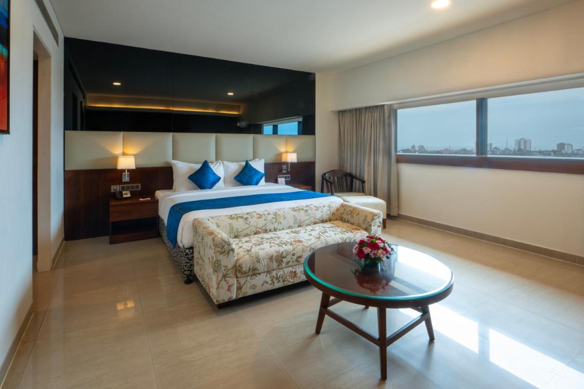 a hotel room with a bed and a coffee table at The Raviz Calicut in Kozhikode