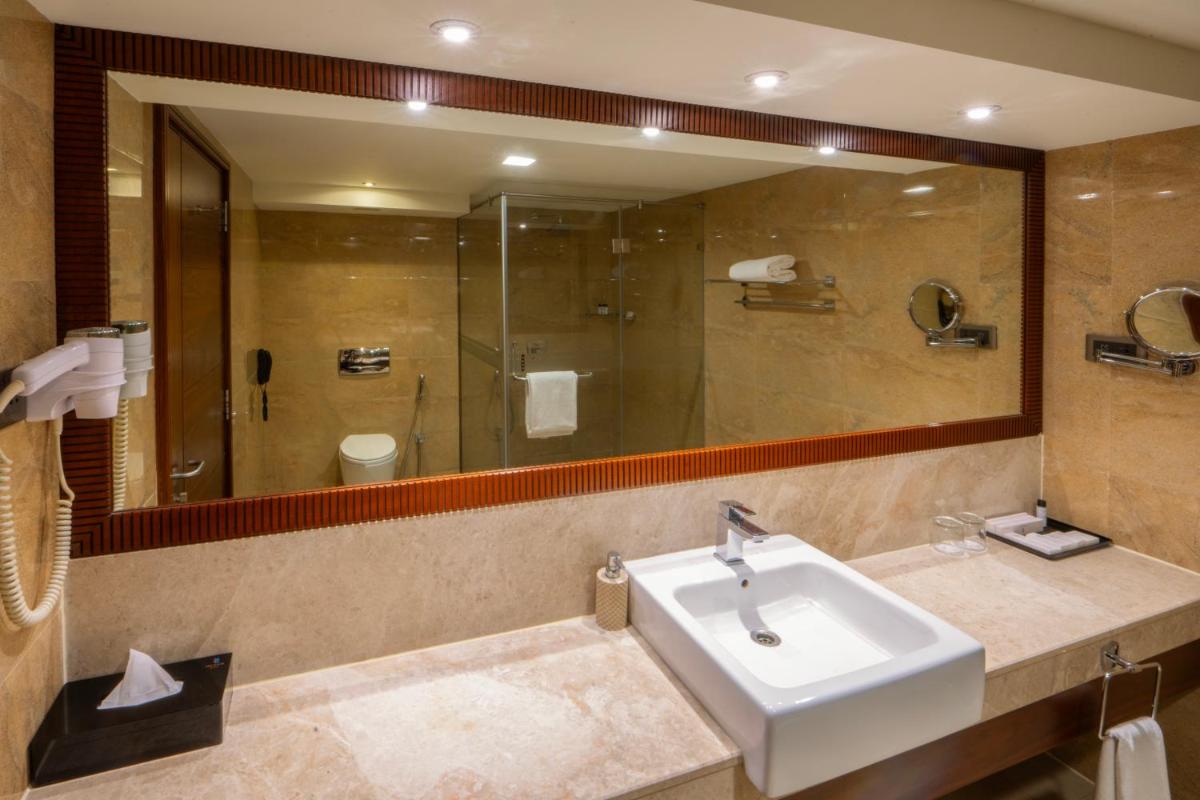 a bathroom with a sink and a large mirror at The Raviz Calicut in Kozhikode