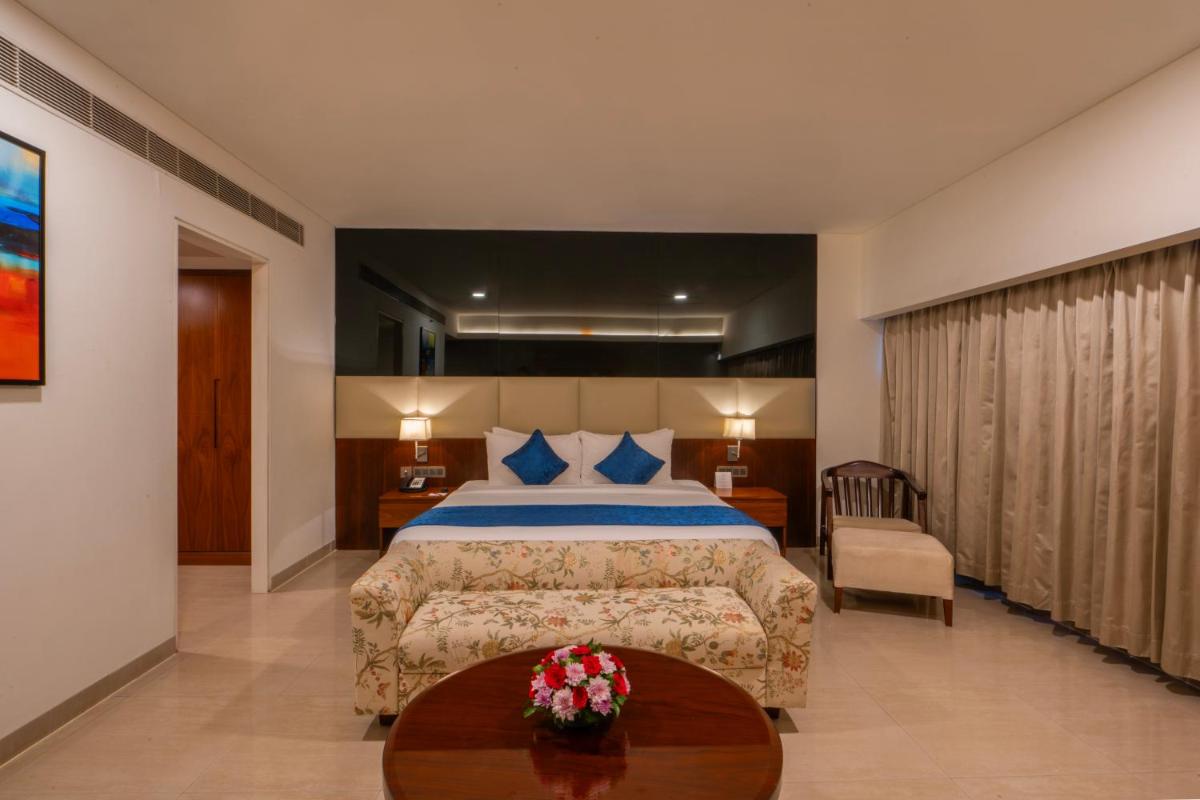 a hotel room with a bed and a table at The Raviz Calicut in Kozhikode