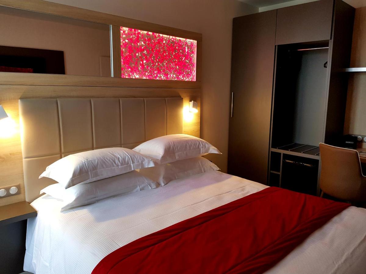 Un ou plusieurs lits dans un hébergement de l'établissement Brit Hotel de Grignan Vichy