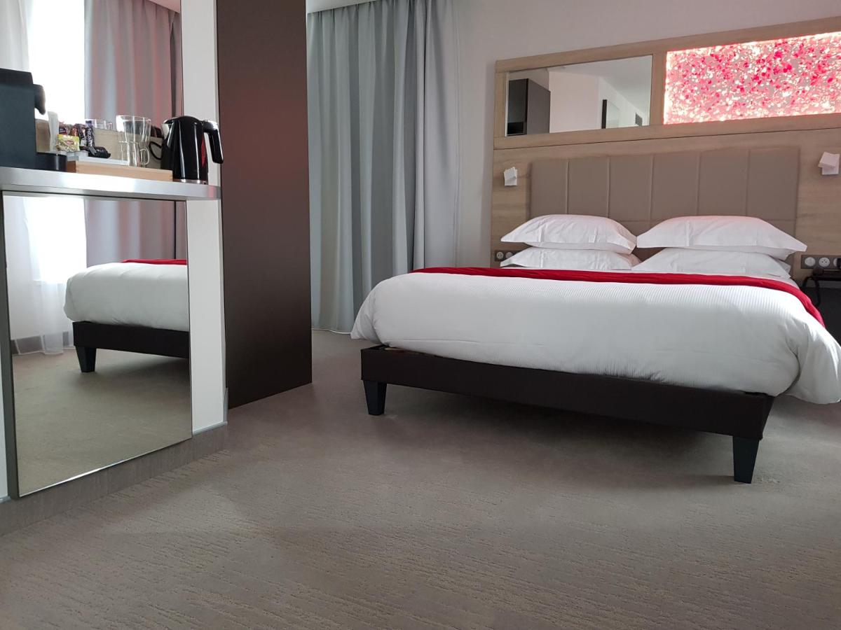 Un ou plusieurs lits dans un hébergement de l'établissement Brit Hotel de Grignan Vichy