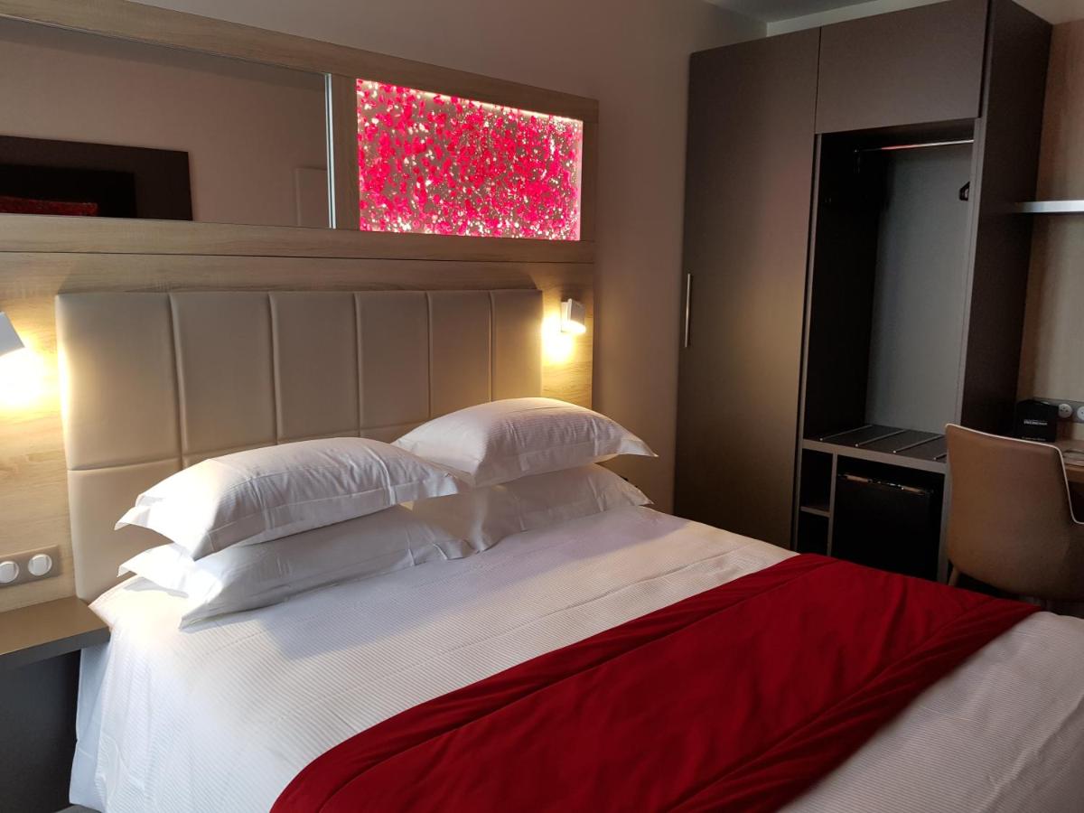 Un ou plusieurs lits dans un hébergement de l'établissement Brit Hotel de Grignan Vichy