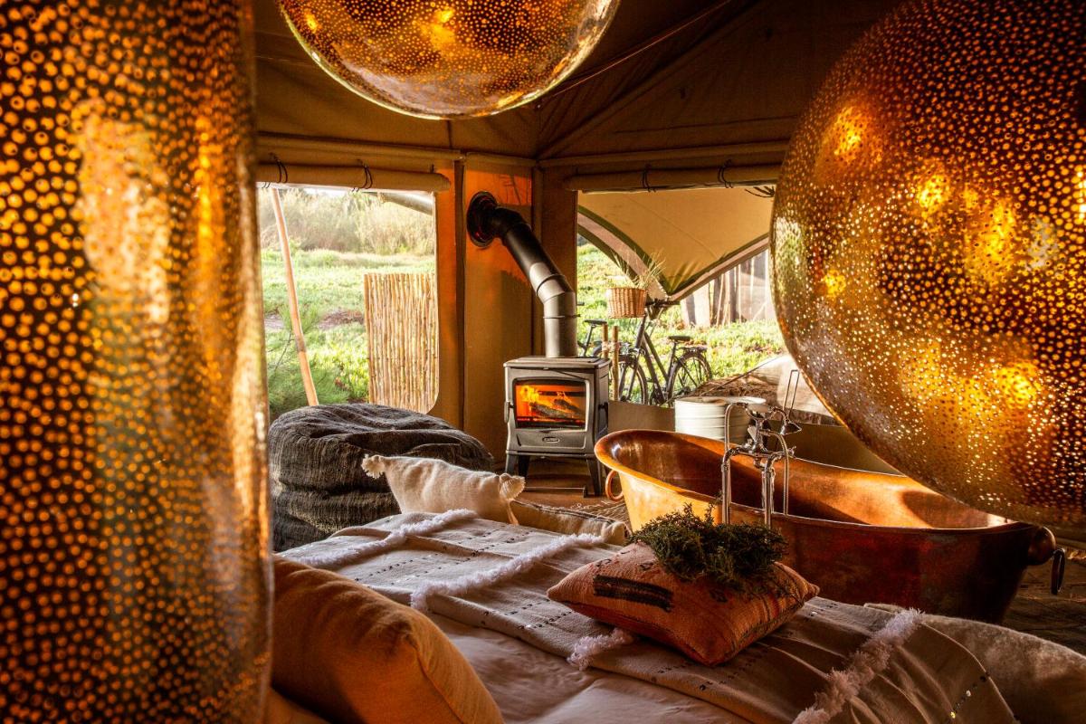 um quarto com banheira e fogão em uma barraca em Areias do Seixo Hotel em Santa Cruz