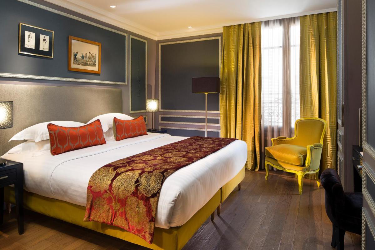 une chambre d'hôtel avec un grand lit et une chaise jaune dans l'établissement Hotel & Spa La Belle Juliette, à Paris