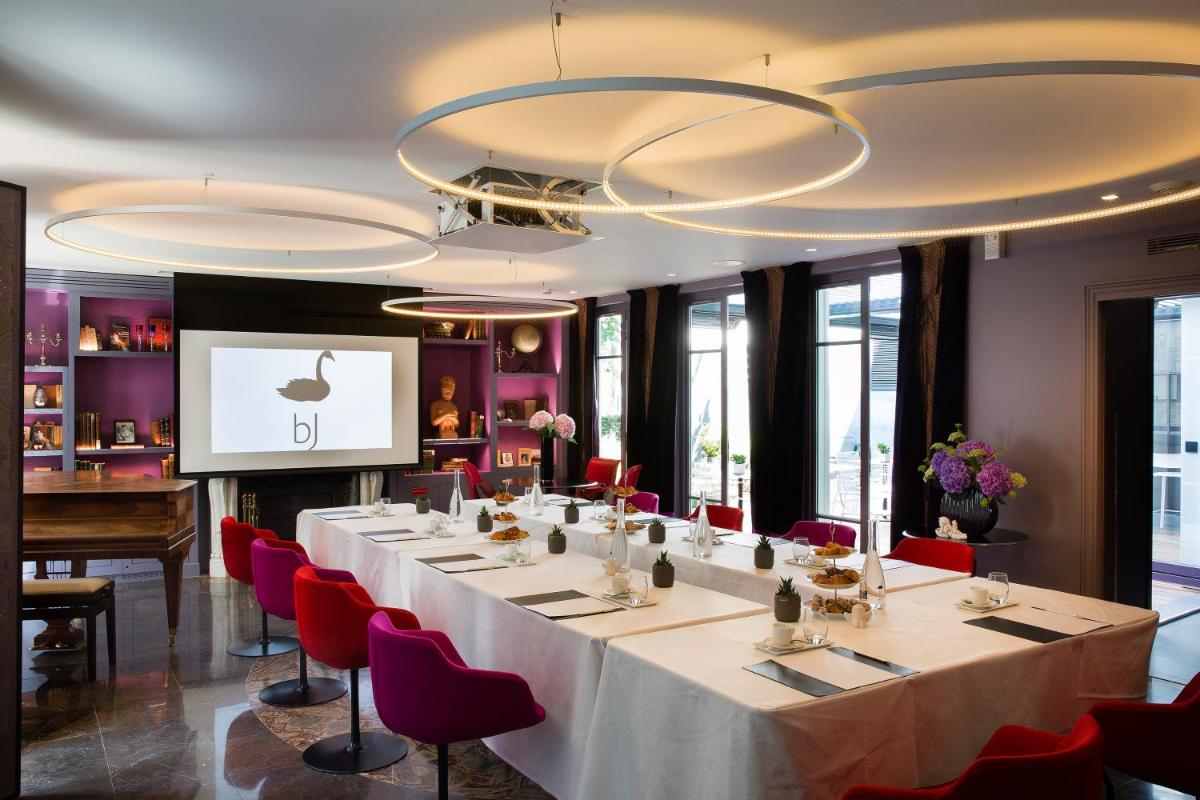 une salle de conférence avec une longue table et des chaises rouges dans l'établissement Hotel & Spa La Belle Juliette, à Paris 55 autres photos