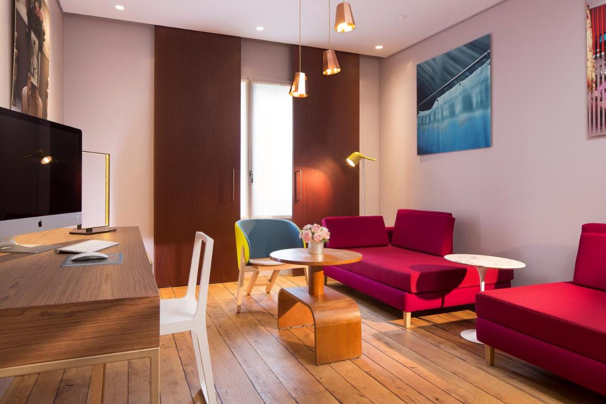 un salon avec un canapé rouge et une table dans l'établissement Hotel & Spa La Belle Juliette, à Paris