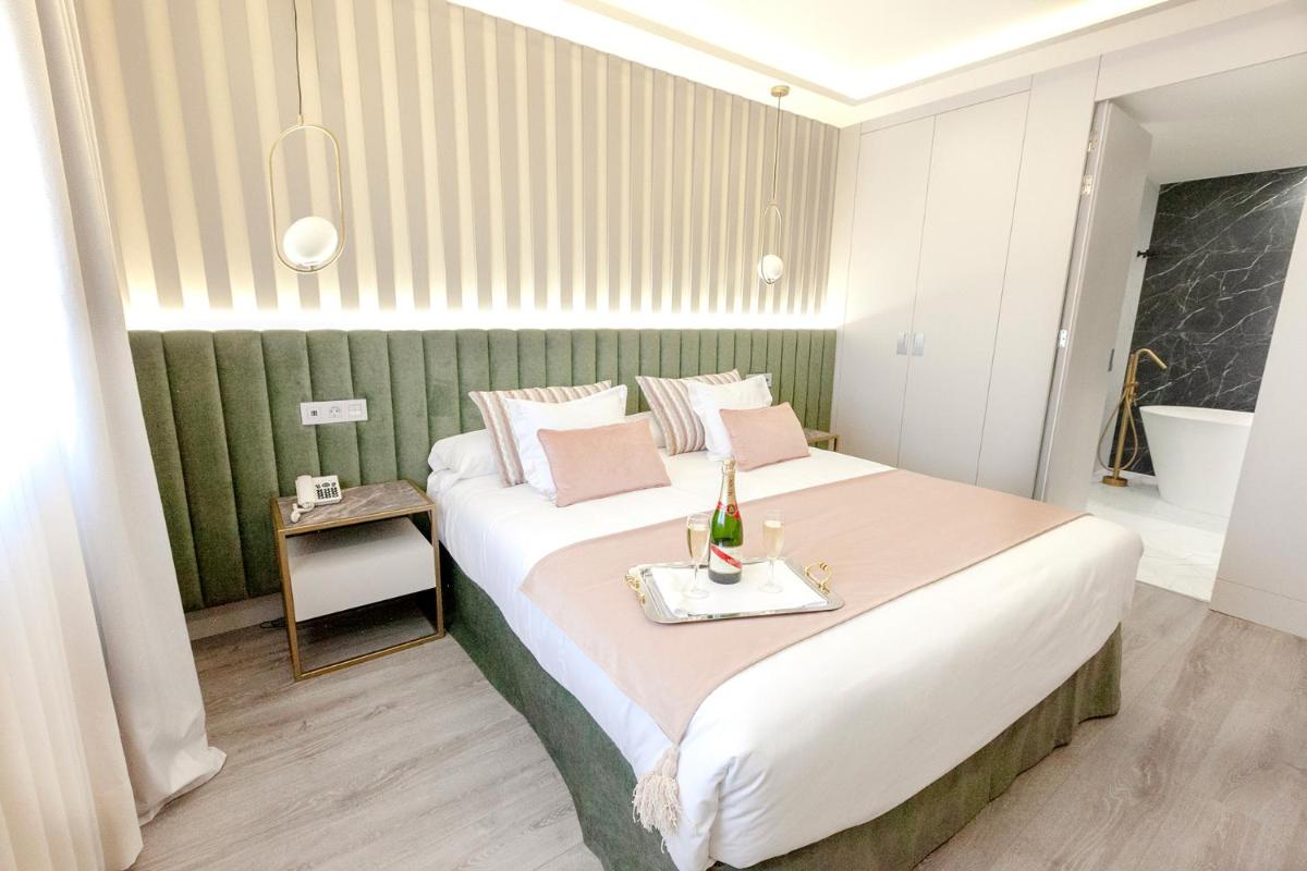 Un dormitorio con una cama grande y una botella de champán. en Hotel Alfonso VIII, en Soria
