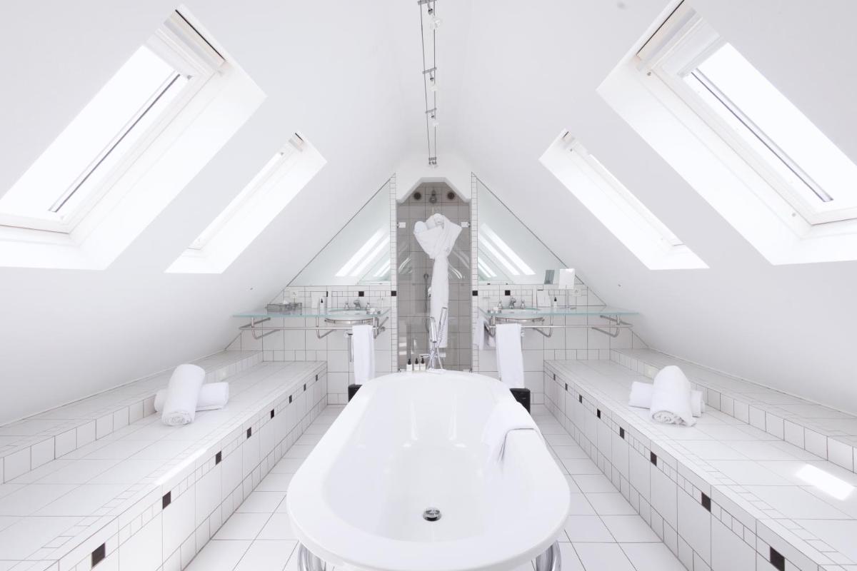 une salle de bains blanche avec une tour d'horloge en arrière-plan dans l'établissement L'Agapa Hôtel - Spa Codage, à Perros-Guirec