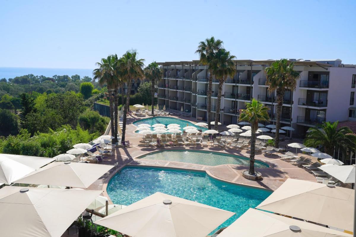- une vue sur la piscine du complexe et ses parasols dans l'établissement Thalazur Antibes - Résidence & Spa, à Antibes