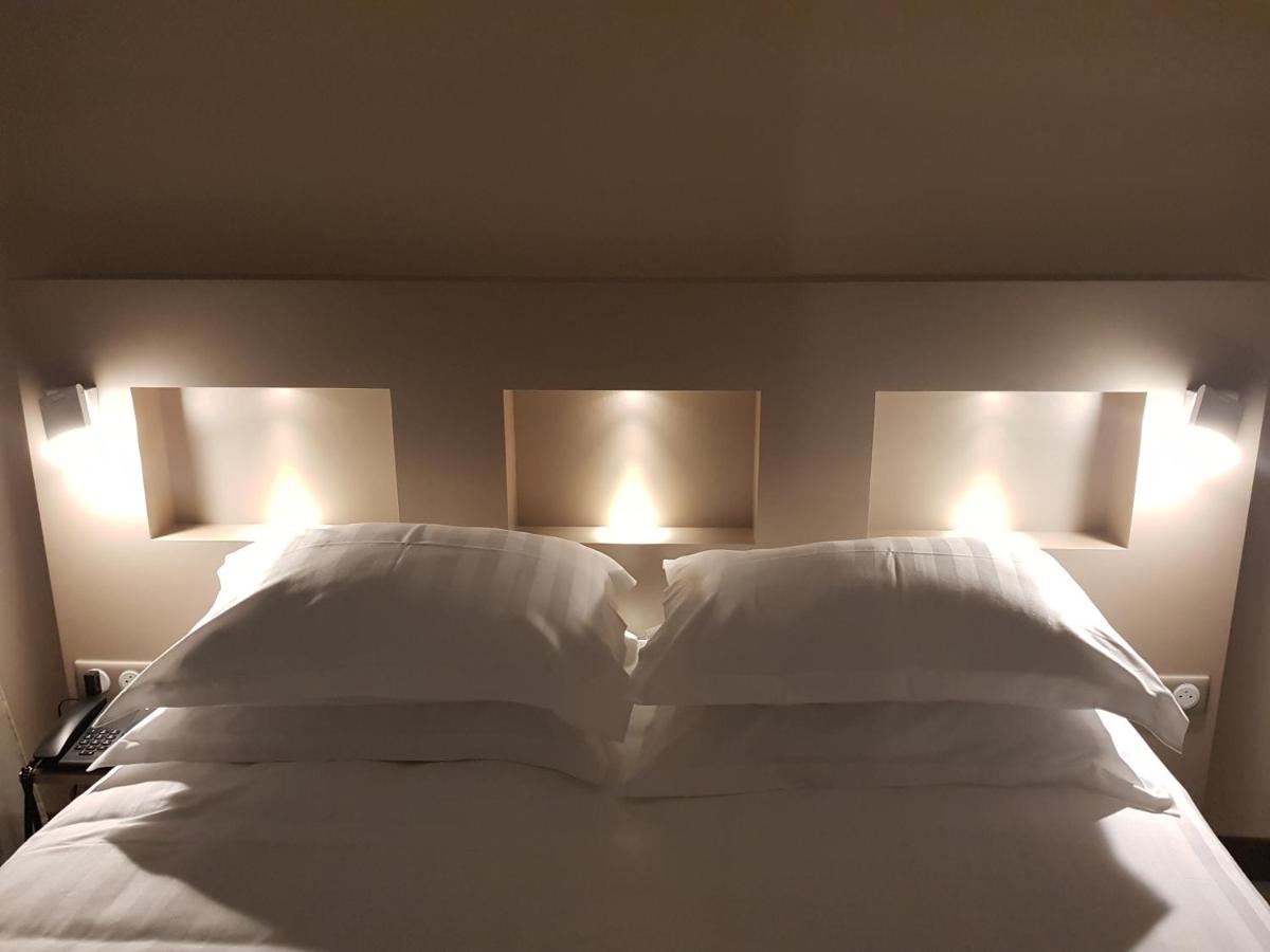 Un ou plusieurs lits dans un hébergement de l'établissement Brit Hotel de Grignan Vichy