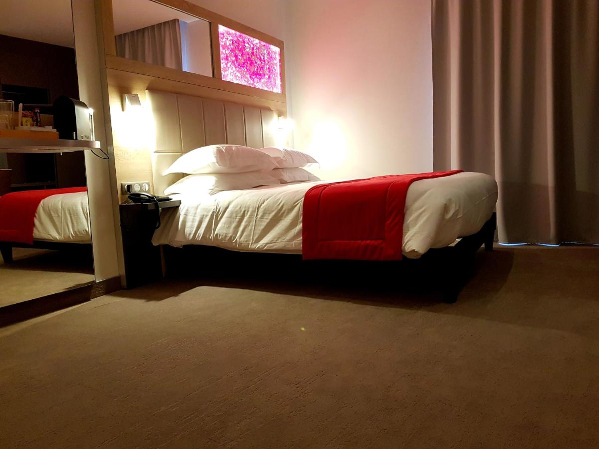 Un ou plusieurs lits dans un hébergement de l'établissement Brit Hotel de Grignan Vichy