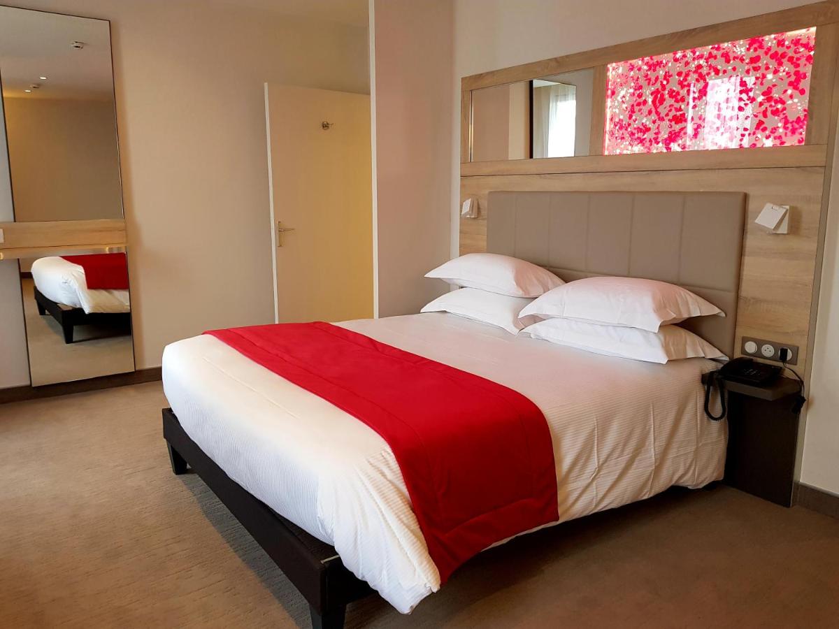 Un ou plusieurs lits dans un hébergement de l'établissement Brit Hotel de Grignan Vichy