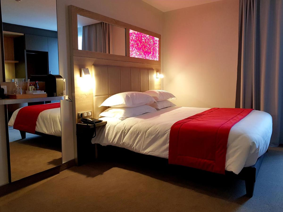 Un ou plusieurs lits dans un hébergement de l'établissement Brit Hotel de Grignan Vichy