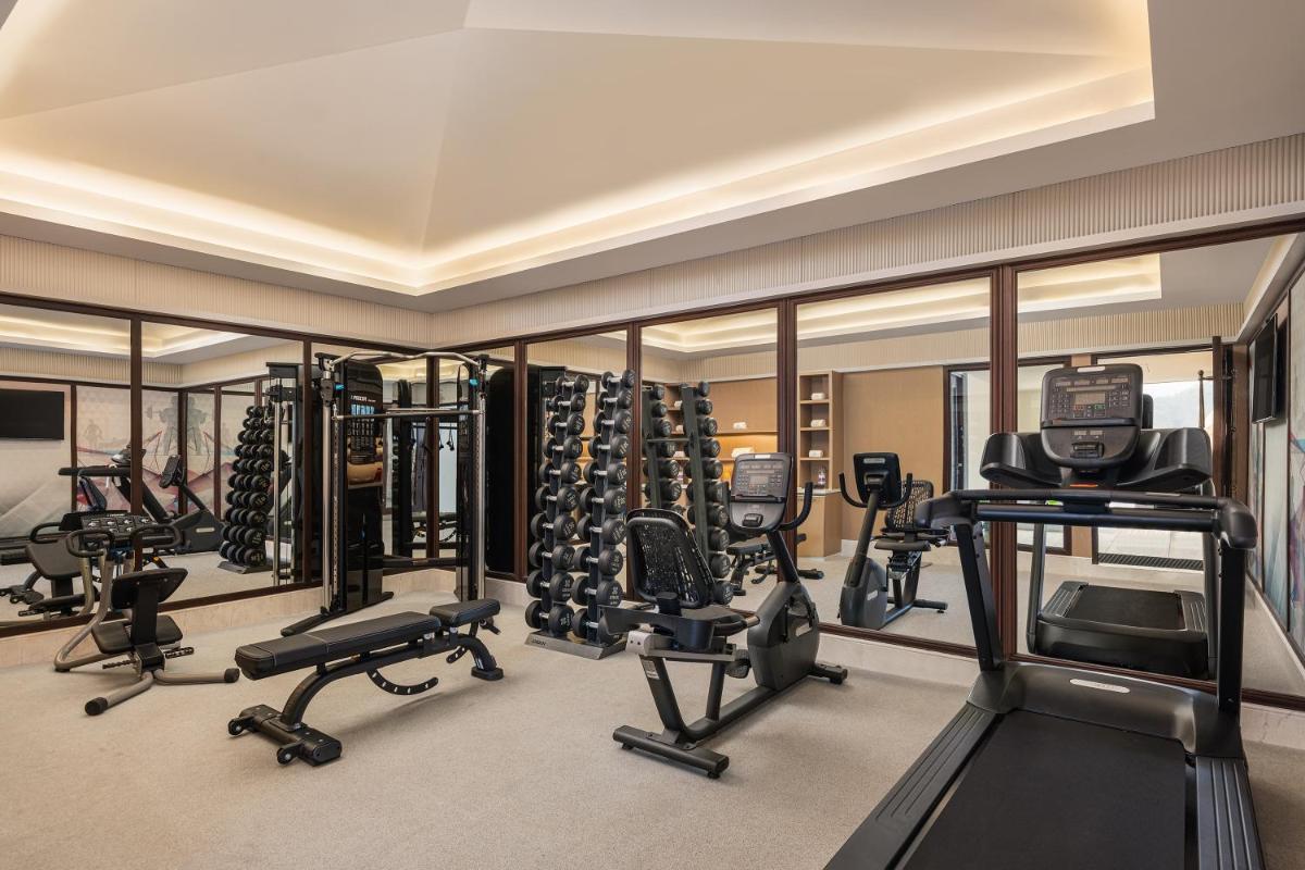 a gym with treadmills and elliptical machines at Pilibhit House, Haridwar – IHCL SeleQtions in Haridwār