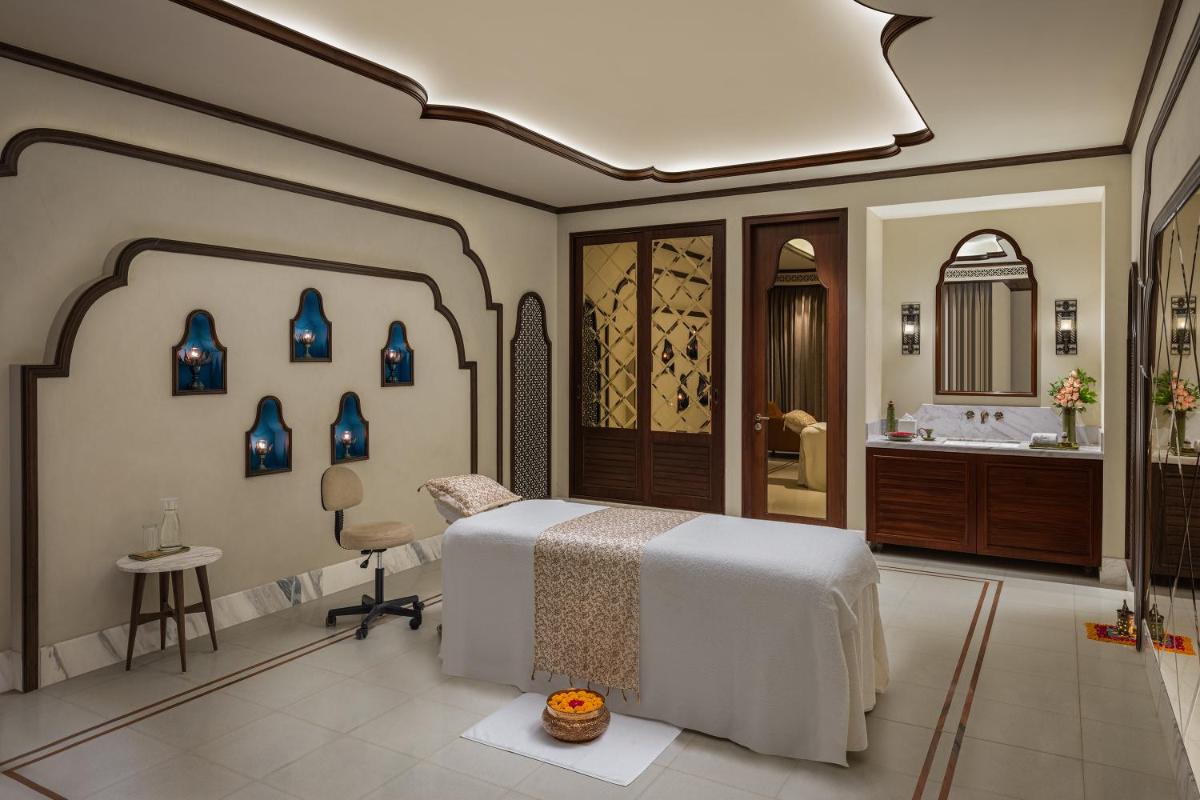 a bedroom with a large bed and a bathroom at Pilibhit House, Haridwar – IHCL SeleQtions in Haridwār
