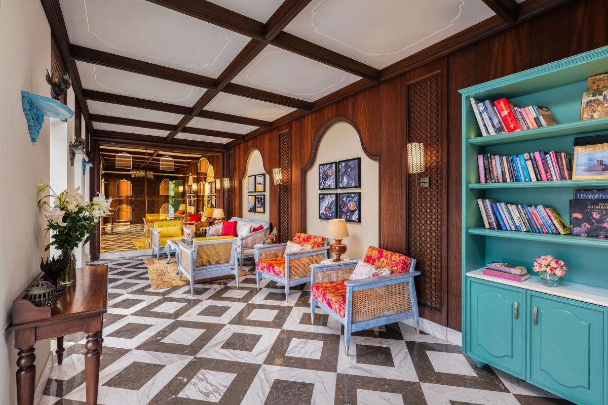 a living room with blue book shelves and chairs at Pilibhit House, Haridwar – IHCL SeleQtions in Haridwār
