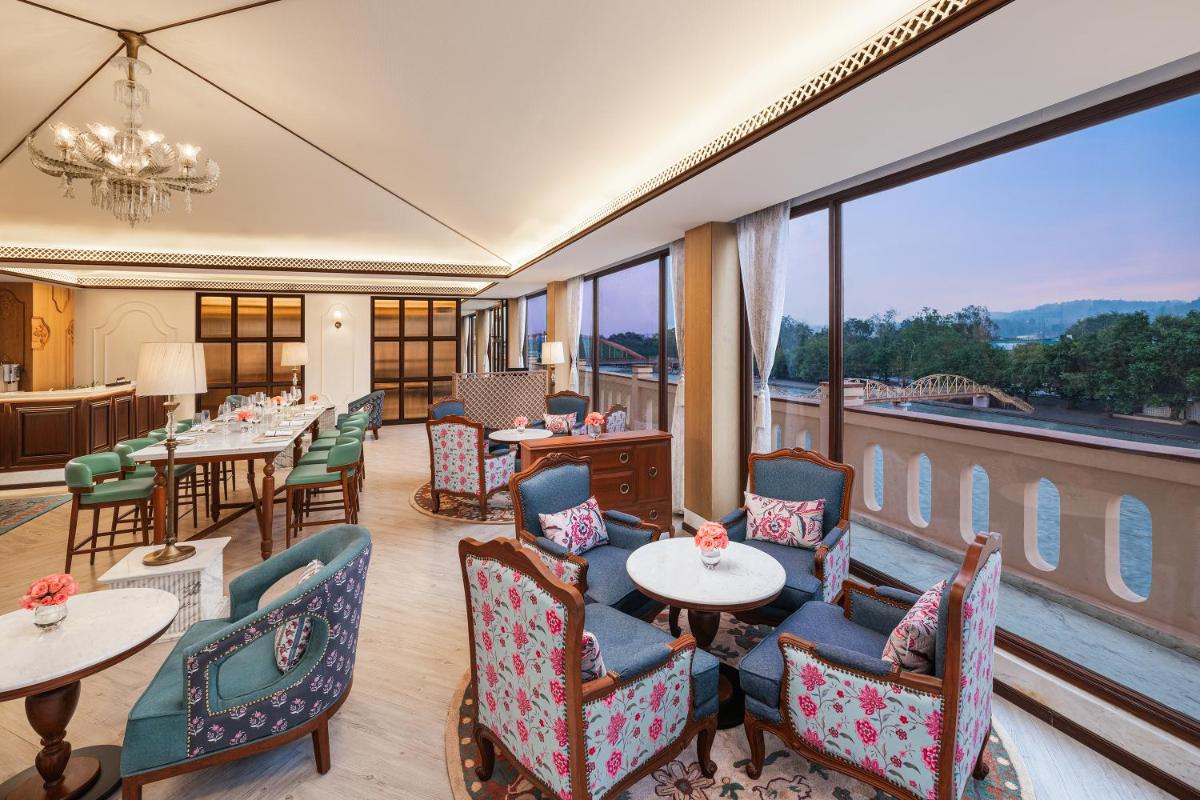 a restaurant with tables and chairs and a large window at Pilibhit House, Haridwar – IHCL SeleQtions in Haridwār