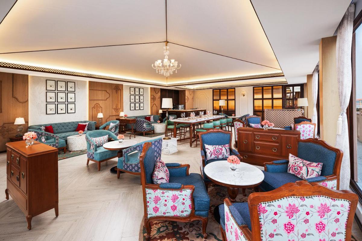 a hotel lobby with tables and chairs at Pilibhit House, Haridwar – IHCL SeleQtions in Haridwār