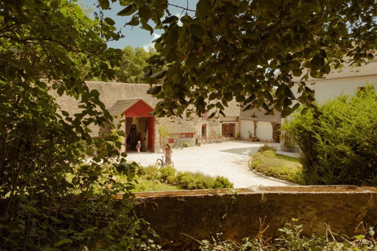 une maison avec une grange rouge et une allée dans l'établissement Le Barn, à Bonnelles