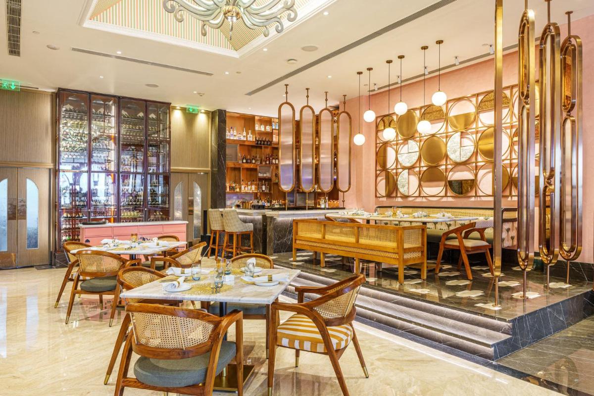 a restaurant with tables and chairs and a bar at Crowne Plaza Today Gurugram by IHG in Gurgaon