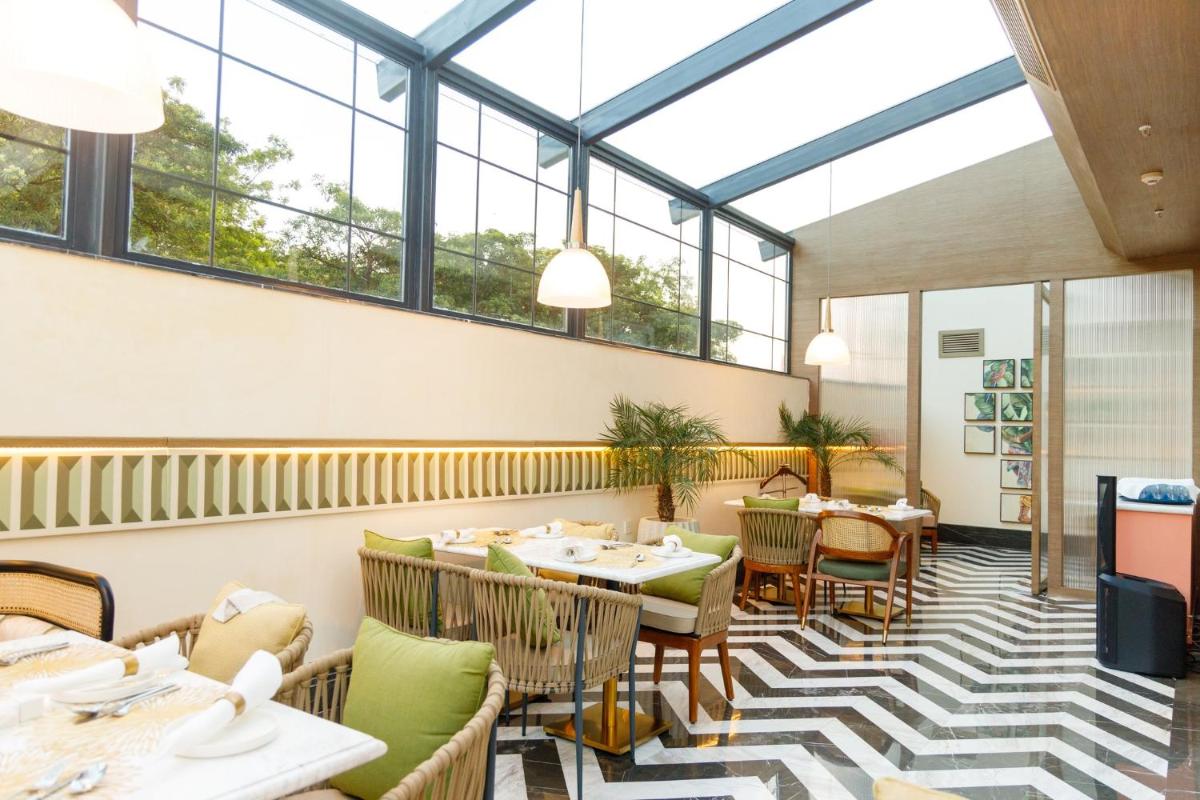 a restaurant with tables and chairs and windows at Crowne Plaza Today Gurugram by IHG in Gurgaon