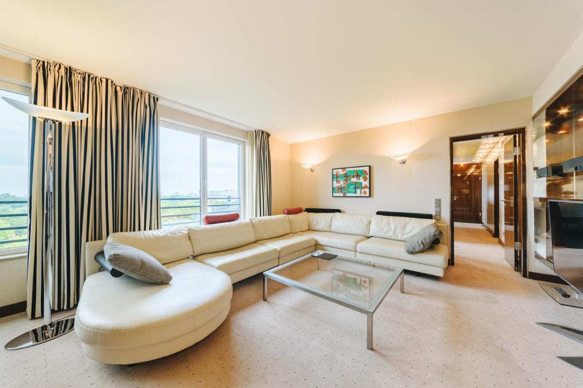 ein Wohnzimmer mit Couch und Tisch in der Unterkunft Pullman Berlin Schweizerhof in Berlin