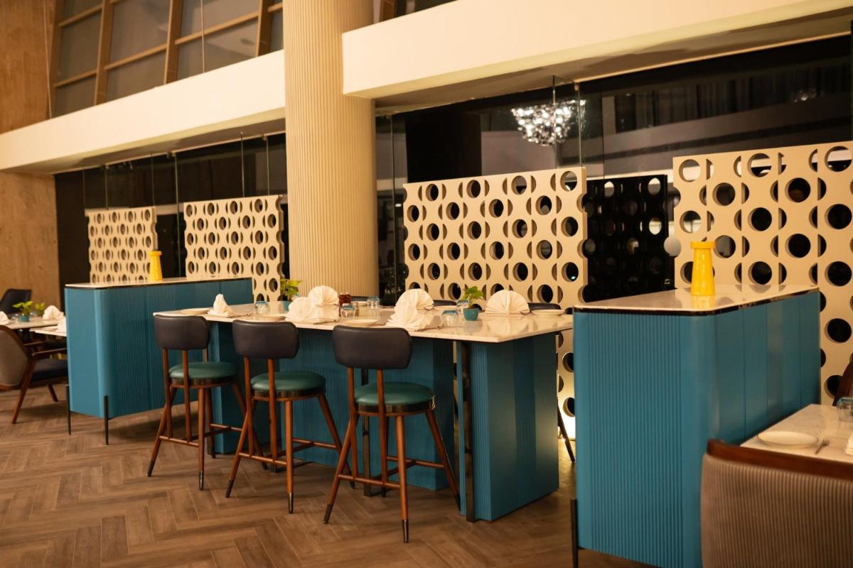a restaurant with blue counters and bar stools at Crowne Plaza Ahmedabad City Centre by IHG in Ahmedabad