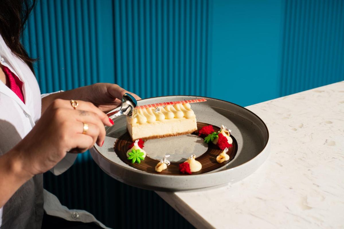 a woman cutting into a cake on a pan at Crowne Plaza Ahmedabad City Centre by IHG in Ahmedabad