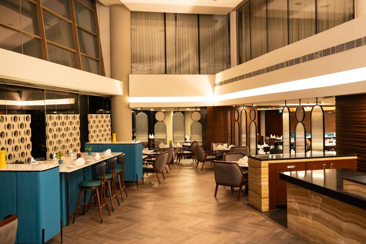 a dining room with tables and chairs at Crowne Plaza Ahmedabad City Centre by IHG in Ahmedabad