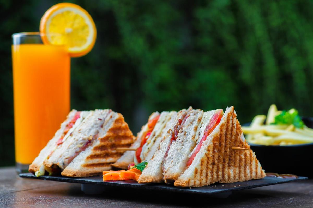 a plate of sandwiches and a glass of orange juice at The Park Kolkata in Kolkata
