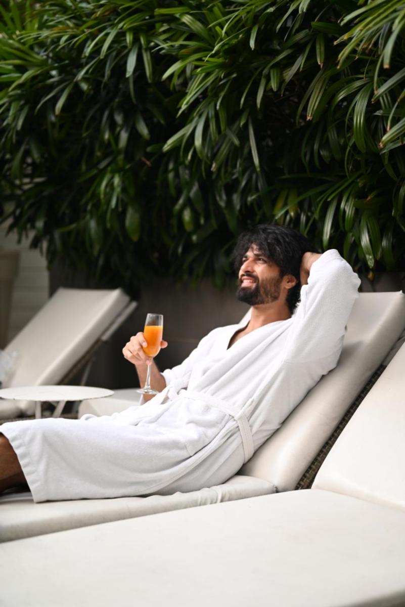 a man sitting in a bath tub with a drink at The Park Kolkata in Kolkata