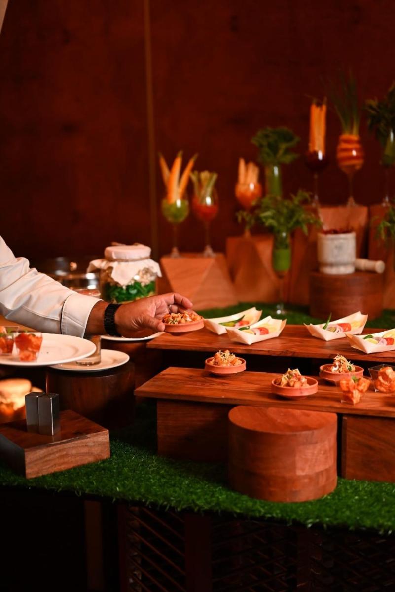 a person holding a plate of food on a table at The Park Kolkata in Kolkata