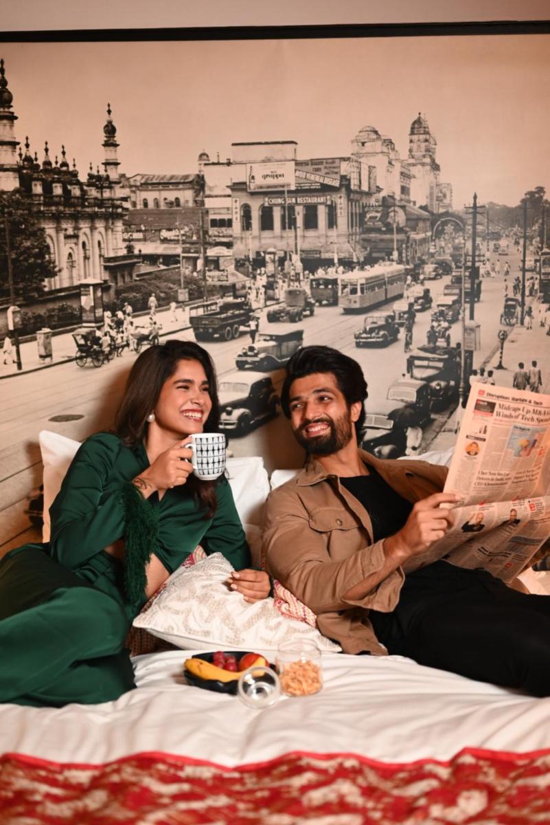 a man and a woman sitting on a bed with food at The Park Kolkata in Kolkata