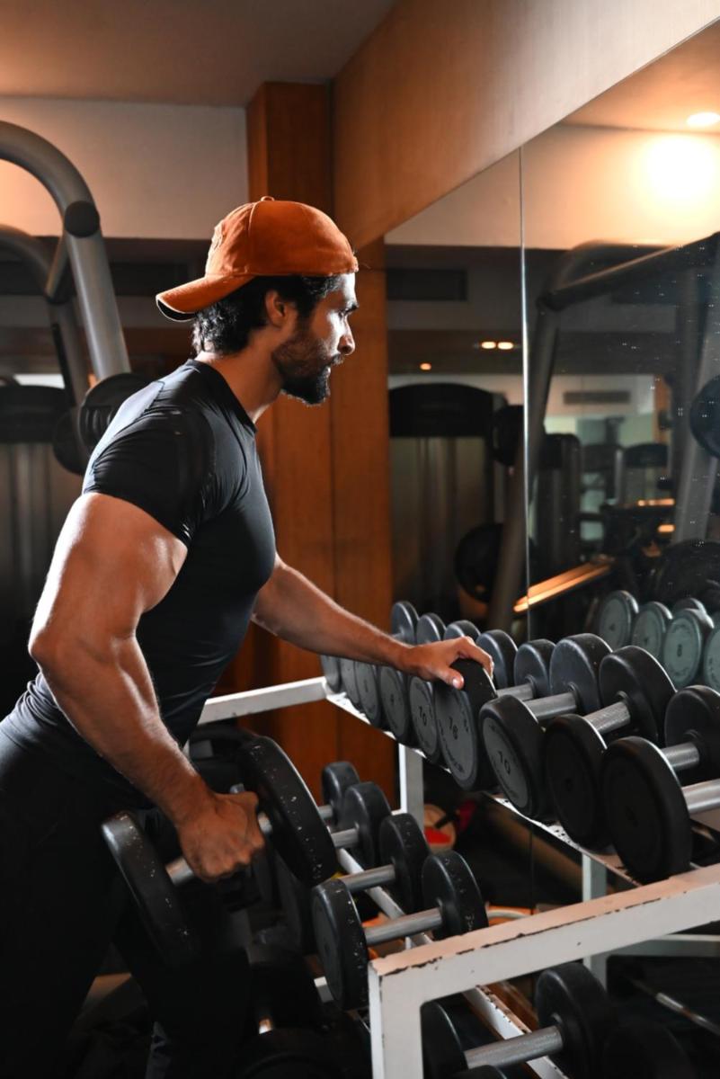 a man in a gym looking at a rack of weights at The Park Kolkata in Kolkata