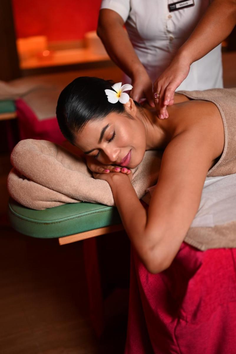 a woman getting a massage with a flower on her head at The Park Kolkata in Kolkata