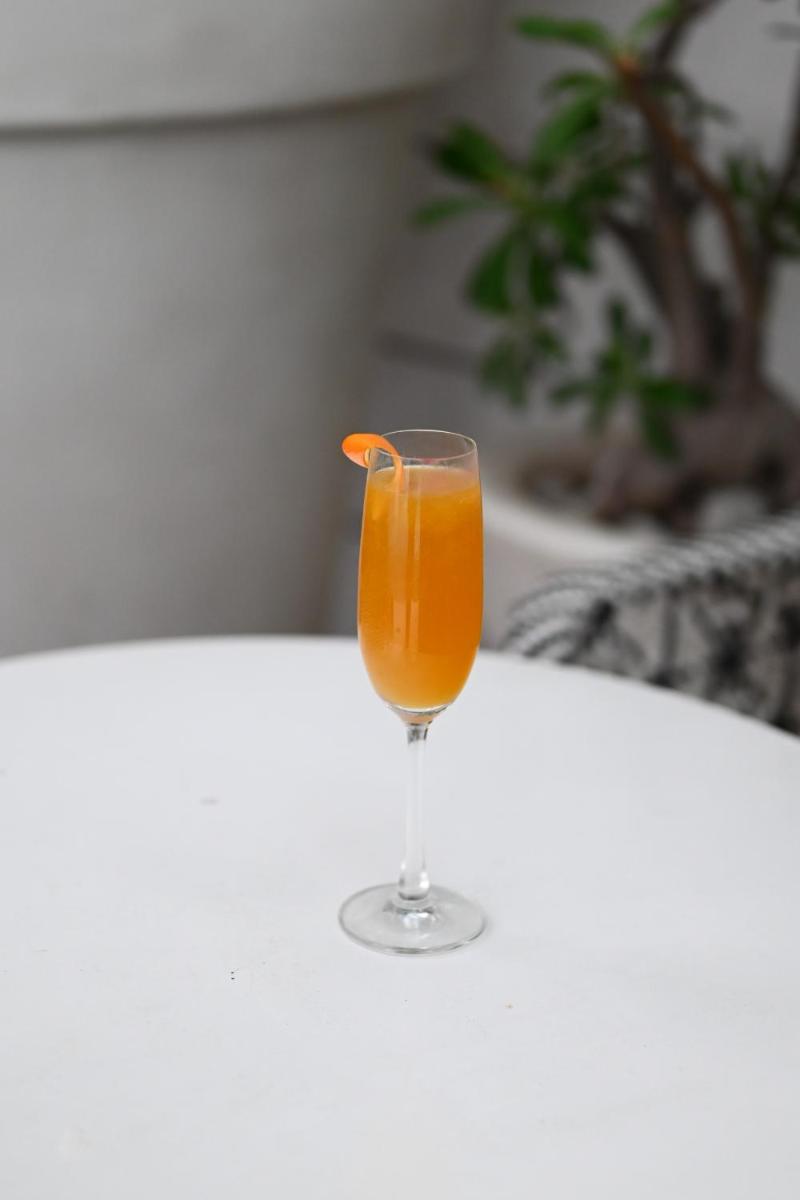 a glass of orange juice sitting on a table at The Park Kolkata in Kolkata