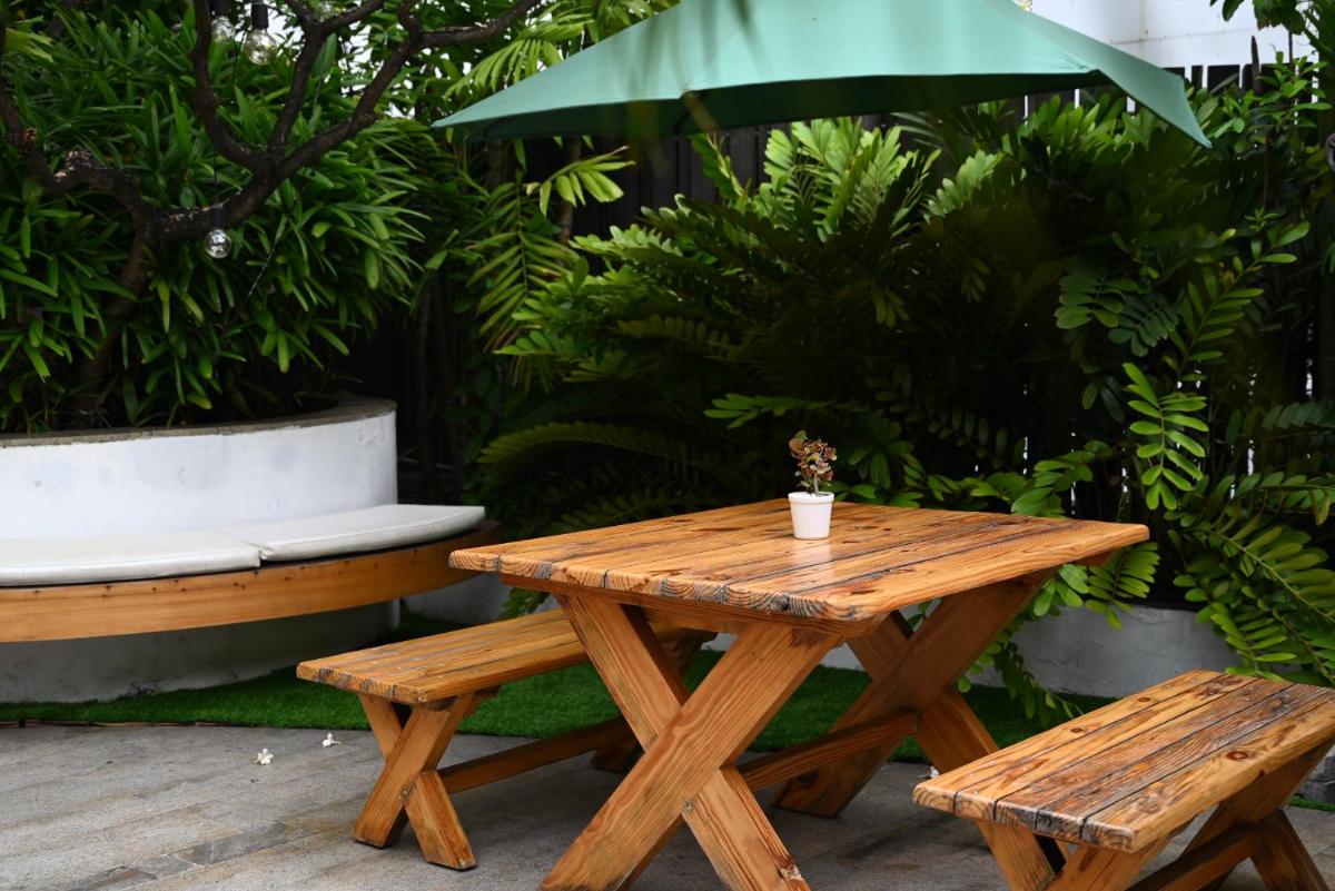 a wooden picnic table and bench with a cup on it at The Park Kolkata in Kolkata